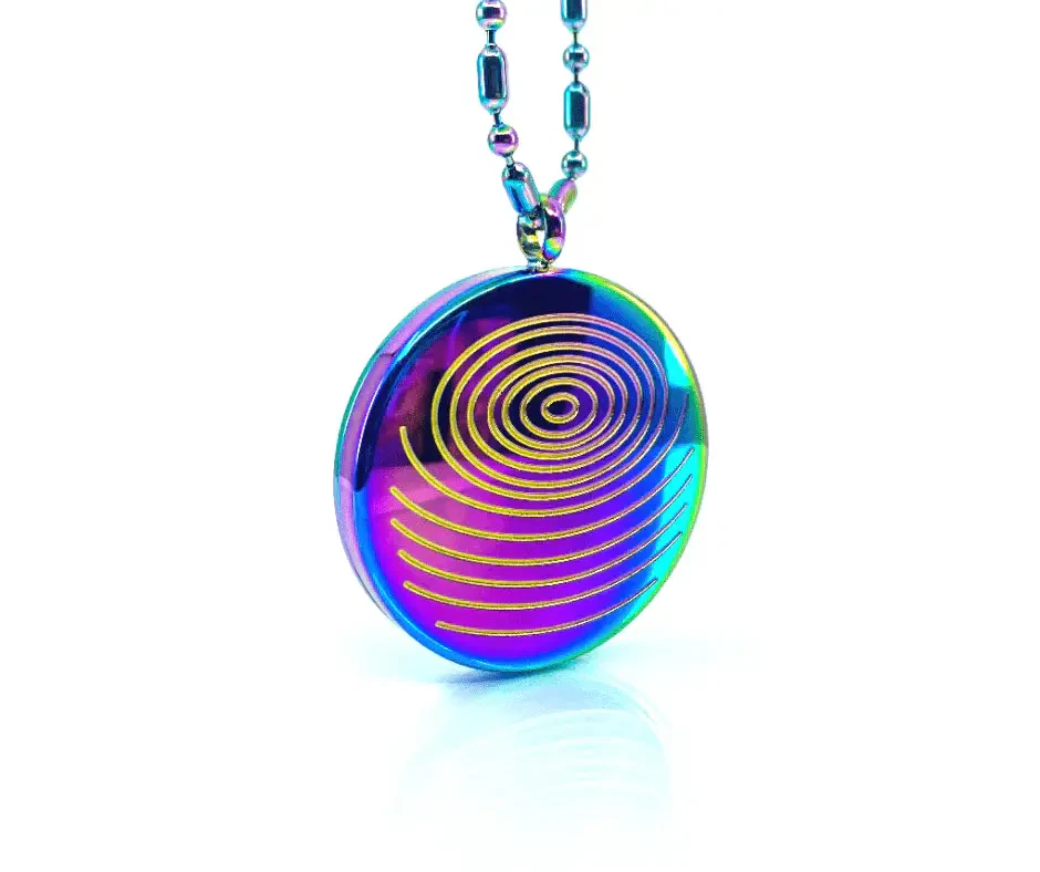 A shiny, oval-shaped necklace pendant with a rainbow-colored surface and gold spiral lines sits on a matching chain against a white background.