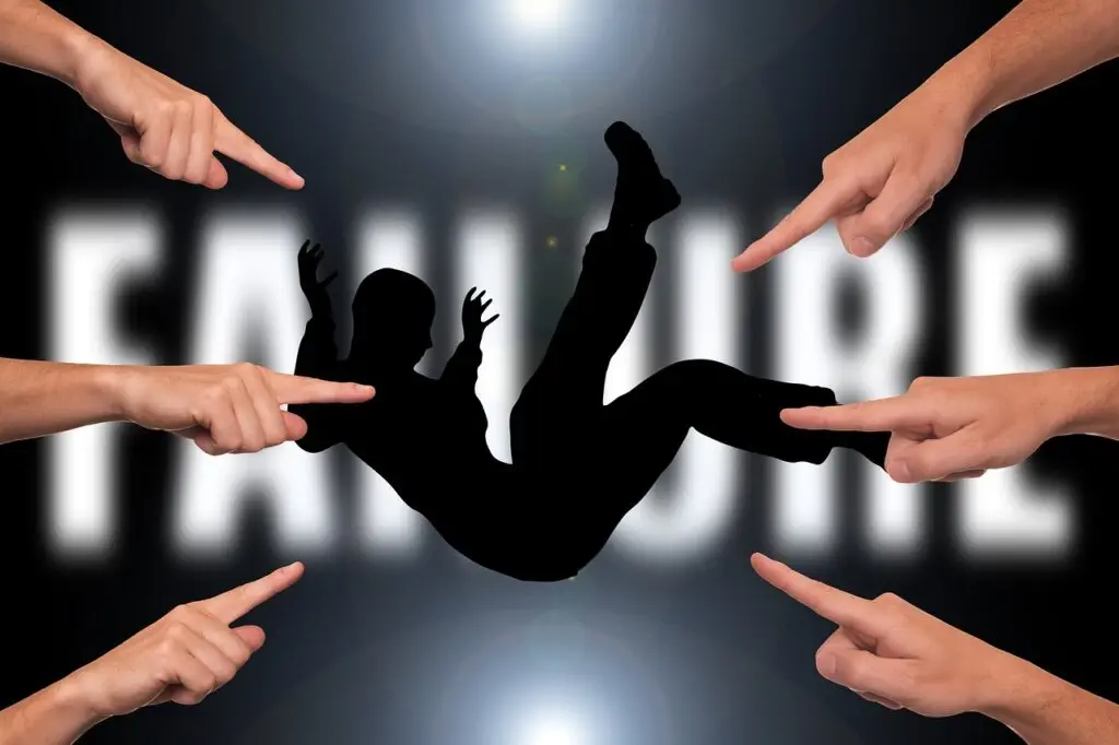 A shadowy figure of someone falling, with many hands pointing at them, represents the pressure felt by entrepreneurs. In the background, the word FAILURE is blurry. This scene creates a dramatic and blaming atmosphere for those trying to succeed in business.